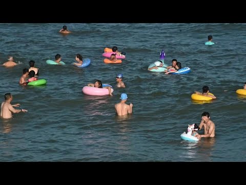 روّاد شاطئ صيني يُزيّنون مياهه بالعوامات الملونة